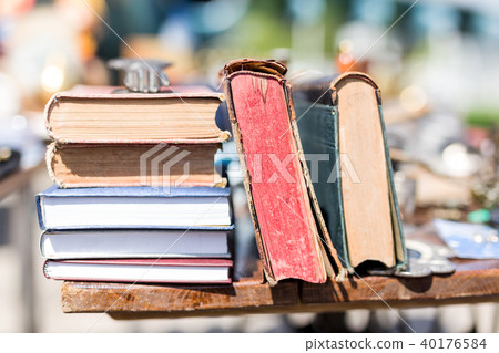 Old aged books at flea market. Vintage retro literature on wooden table outdoors. Street swap meet Old aged books at flea market. Vintage retro literature on wooden table outdoors. Street swap meet 40176584