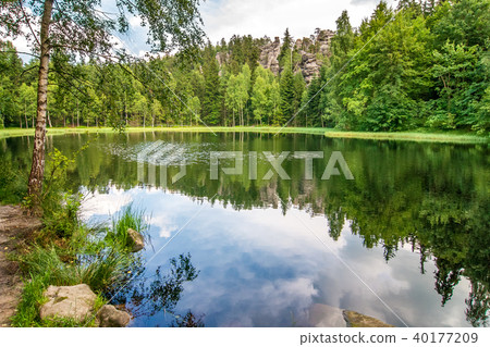 Lake with a reflection of blue cloudy sky. Lake with a reflection of blue cloudy sky. 40177209