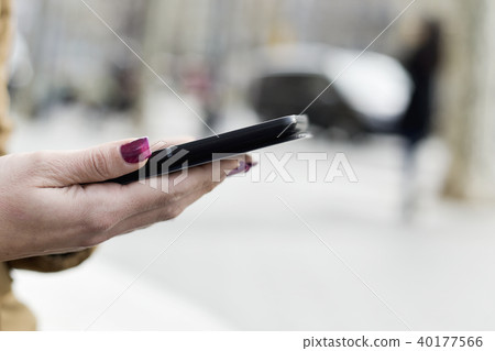 woman using a tablet in the street. 40177566
