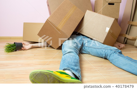 Image of man in jeans lying under cardboard boxes Image of man in jeans lying under cardboard boxes 40178479