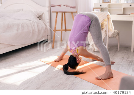 Serious young woman doing some exercises Serious young woman doing some exercises 40179124
