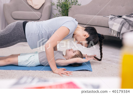 Cheerful young mother doing push-ups 40179384
