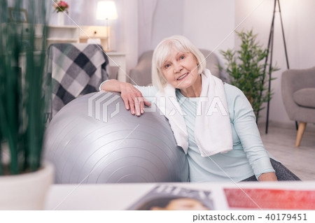 Cute elderly woman leaning on yoga ball and smiling 40179451
