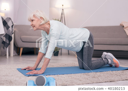 Beautiful elderly woman standing in cow pose 40180213