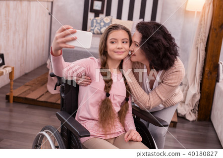 Pleased disabled girl and woman collecting memory 40180827