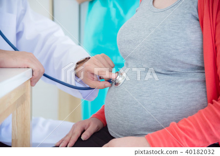 doctor checking pregnant woman by stethoscope  40182032