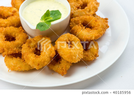 Squid rings fried in batter with white sauce on white plate on white background Squid rings fried in batter with white sauce on white plate on white background 40185956