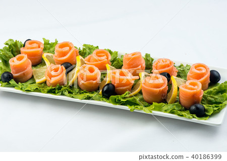 salmon snack on lettuce leaf with lemon and olives on white plate on white background salmon snack on lettuce leaf with lemon and olives on white plate on white background 40186399