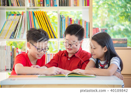Three student reading book together in library Three student reading book together in library 40189842