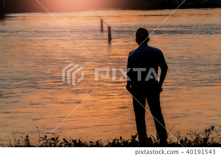 Silhouette young man standing with seeing  river a 40191543