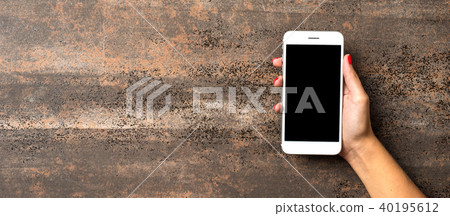Female hand holding white mobile phone Female hand holding white mobile phone 40195612
