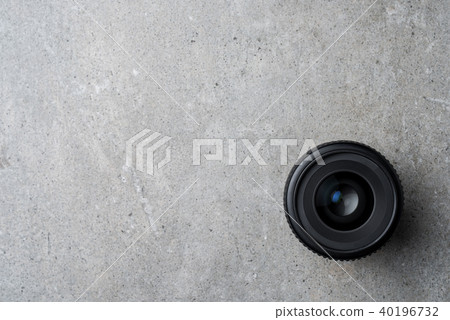 Modern camera lens on gray stone table Modern camera lens on gray stone table 40196732