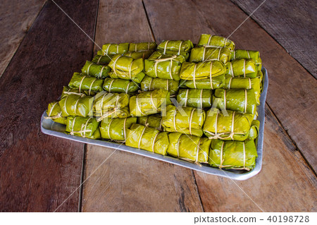 Bananas with sticky rice wrapped with banana leaf. Bananas with sticky rice wrapped with banana leaf. 40198728