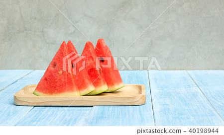 Red watermelon on a plate and blue wooden table. 40198944