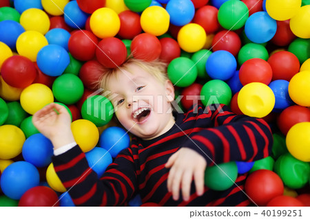 Happy little boy having fun in ball pit with colorful balls 40199251