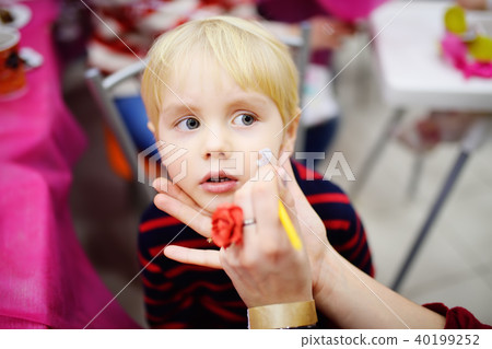Face painting for cute little boy during kids birthday party Face painting for cute little boy during kids birthday party 40199252