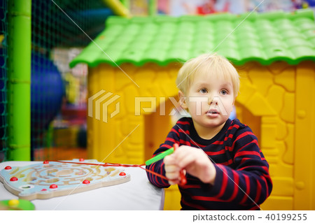Happy little boy having fun with educational toy in play center Happy little boy having fun with educational toy in play center 40199255