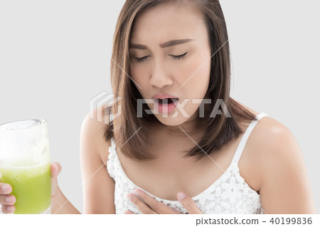 Asian woman is squeamish from the juice against gray background. 40199836