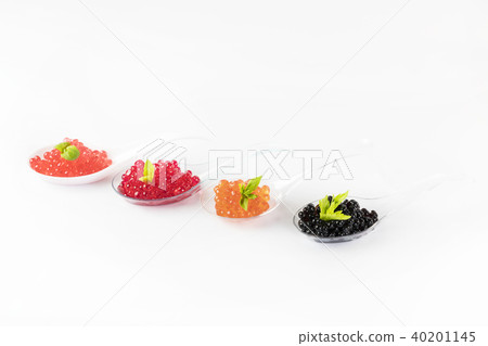 Plastic spoons with fish caviar on a white backgro 40201145