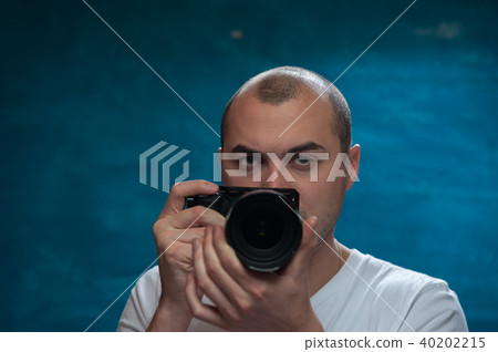 Male professional photographer posing with camera Male professional photographer posing with camera 40202215