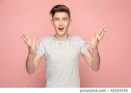 The young attractive man looking suprised isolated on pink The young attractive man looking suprised isolated on pink 40204546