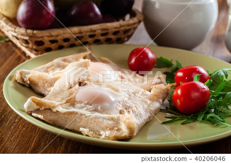 Crepes with ham, cheese and poached egg on a plate 40206046