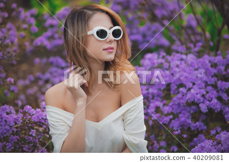 girl in white sunglasses near purple flowers 40209081