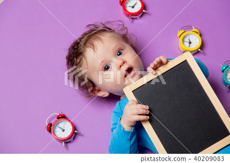 baby with alarm clock and blackboard 40209083