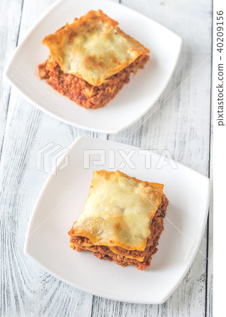 Portion of lasagne on the white plate Portion of lasagne on the white plate 40209156