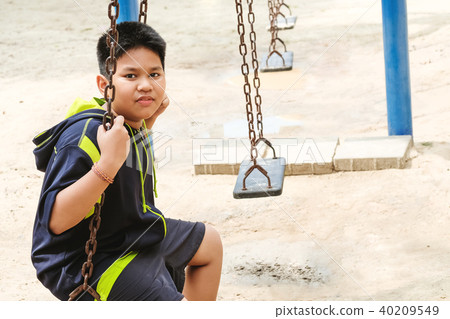 Happy asian sport boy play on swing playground in Garden. Happy asian sport boy play on swing playground in Garden. 40209549