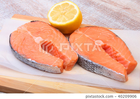 fresh raw salmon with spices and lemon on wooden cutting board. ready for cookin fresh raw salmon with spices and lemon on wooden cutting board. ready for cookin 40209906