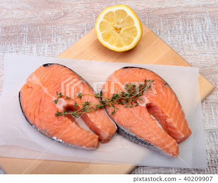 fresh raw salmon with spices and lemon on wooden cutting board. ready for cookin fresh raw salmon with spices and lemon on wooden cutting board. ready for cookin 40209907