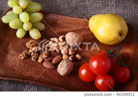 Fresh organic fruits and vegetables on wooden Serving tray. Assorted apple, pear, grapes, tomatoes Fresh organic fruits and vegetables on wooden Serving tray. Assorted apple, pear, grapes, tomatoes 40209912