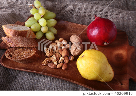 Fresh organic fruits on wood Serving tray. Assorted apple, pear, grapes, dried fruits and nuts. Fresh organic fruits on wood Serving tray. Assorted apple, pear, grapes, dried fruits and nuts. 40209913