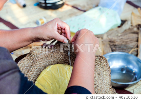 Thai artisans is using a needle weaving sew hat 40210510