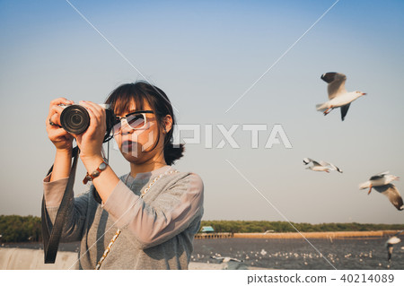 Asian woman talking picture of seascape and birds. Asian woman talking picture of seascape and birds. 40214089