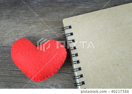 Red heart and blank brown notebook placed on a wooden floor. Red heart and blank brown notebook placed on a wooden floor. 40217388