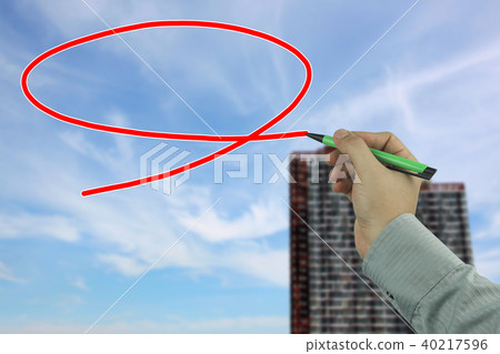 Hand of a businessman holding a green pen writing a message box on blur sky and building background. Hand of a businessman holding a green pen writing a message box on blur sky and building background. 40217596