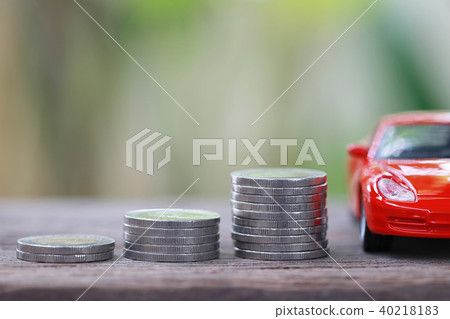 Silver coin of pile with red car model in concept savings to buy a new car. 40218183