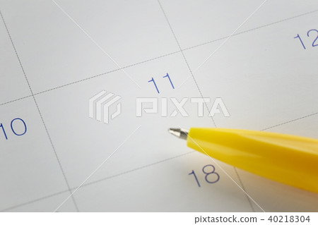 yellow pen points to the number 11 on calendar background. 40218304