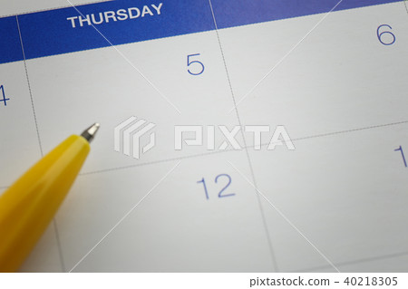 yellow pen points to the number 5 on calendar background. yellow pen points to the number 5 on calendar background. 40218305
