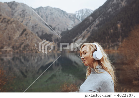 Woman wearing wireless headphones the lake 40222073