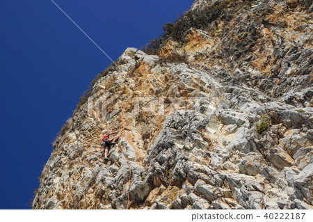 athletic woman climbs a mountain near the sea on a hot summer day 40222187