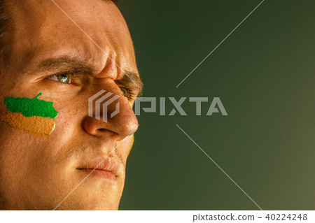 Portrait of a man with the flag of the Brazil painted on him face. Portrait of a man with the flag of the Brazil painted on him face. 40224248