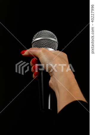 Woman hand with microphone isolated on black 40227996