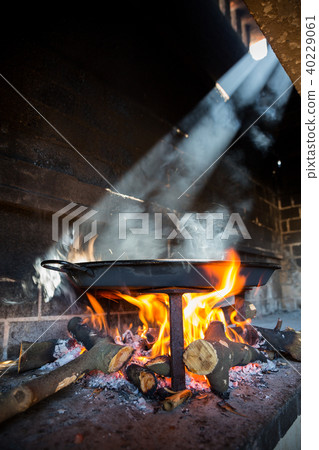 Spanish typical Paella on fire and sun ray light, side view 40229061