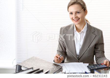 Portrait of female bookkeeper or financial inspector making report, calculating or checking balanc Portrait of female bookkeeper or financial inspector making report, calculating or checking balanc 40231143