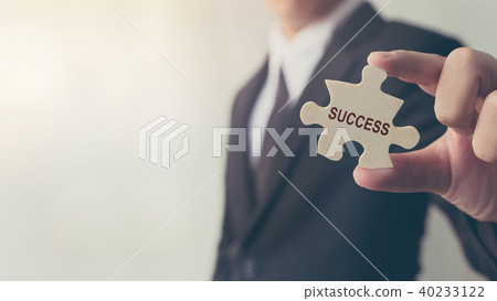 Businessman holding a jigsaw puzzle Businessman holding a jigsaw puzzle 40233122