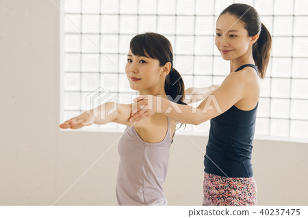 Young Japanese woman and instructor taking yoga lessons at yoga studio 40237475