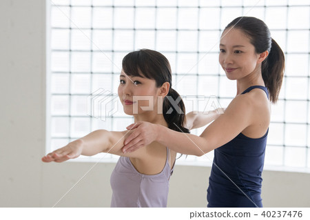 Young Japanese woman and instructor taking yoga lessons at yoga studio 40237476